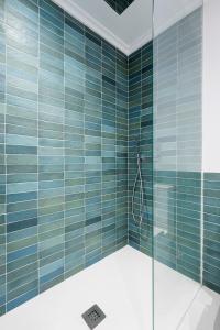 bagno con pareti piastrellate blu e doccia di NEW Apartment & Terrace. Steps to Ondarreta Beach a Añorga-Lugariz