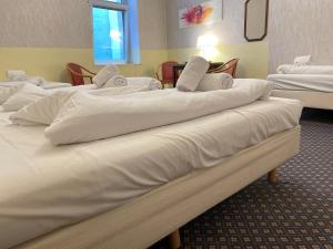 a row of white beds in a hotel room at Hotel Tabor Rooms in Vienna