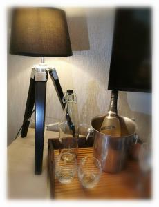 a table with a lamp and a pot on a table at Bed & Bokes aan de Maaskant in Lanaken