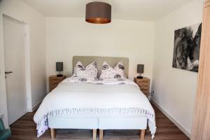 a bedroom with a large white bed with pillows at Ferienwohnung Familienglück in Tutzing