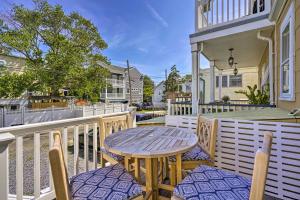 a patio with a wooden table and chairs on a balcony at Charming Ocean City Townhome Walk to Beach! in Ocean City