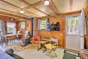Habitación con paredes de madera, mesa y sillas. en Lake Hermit Cabin with Kayaks and Paddleboards!, en Sanbornton