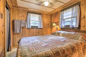 a bedroom with a bed with wooden walls and windows at Lake Hermit Cabin with Kayaks and Paddleboards! in Sanbornton