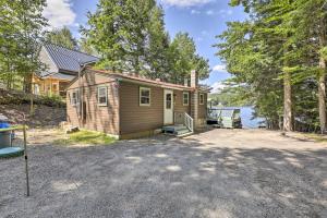 a tiny house with a driveway in front of a lake at Lake Hermit Cabin with Kayaks and Paddleboards! in Sanbornton