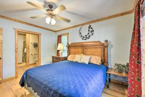 a bedroom with a blue bed and a ceiling fan at Cabin in Resort - half Mi to Guntersville Lake! in Guntersville