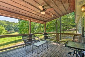 a porch with chairs and a table and a ceiling fan at Cabin in Resort - half Mi to Guntersville Lake! in Guntersville