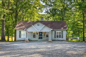 Una casa blanca con una bandera americana. en Cabin in Resort - half Mi to Guntersville Lake!, en Guntersville