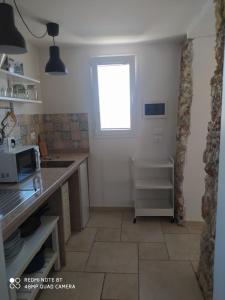 eine Küche mit einer Theke und einem Fenster in der Unterkunft Dimora Monsignore in Torre Lapillo