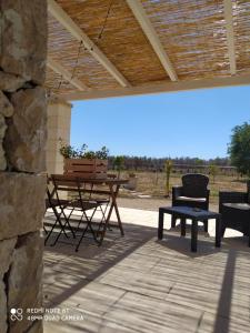 eine Terrasse mit einem Tisch, Stühlen und einer Bank in der Unterkunft Dimora Monsignore in Torre Lapillo