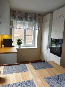 une cuisine avec une table, une fenêtre et un comptoir dans l'établissement Võru Villa, saun, grill, jalgrattad, ideaalne perepuhkus!, à Võru