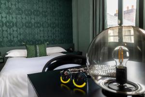 a hotel room with a bed and a table with glasses at L'H&ocirc;tel in Nantes
