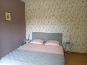 1 dormitorio con 1 cama con 2 almohadas rosas en Le jardin d'Anatole en Bourges