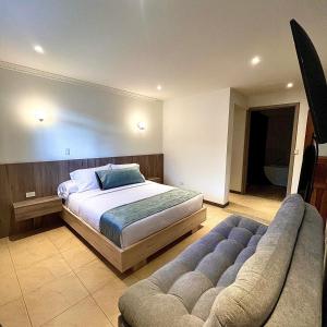 a large bedroom with a bed and a couch at El Zócalo Hotel Boutique in Filandia