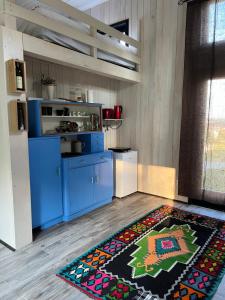 a kitchen with blue cabinets and a rug on the floor at Soko House in Sokolac
