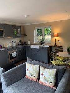 a living room with a couch and a kitchen at Scarborough Hill Country Inn in North Walsham