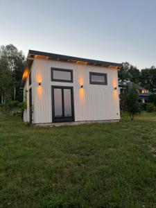 a small white building with lights on it in a field at Soko House in Sokolac
