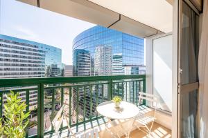 a balcony with a table and a view of a city at BSB STAY EXECUTIVE FLATS PARTICULARES -SHN in Brasilia