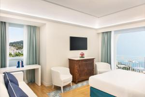 a hotel room with a bed and a large window at Pazziella Garden & Suites in Capri