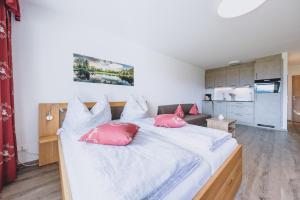 een slaapkamer met een groot bed met rode kussens bij Appartement Farina in Kaprun