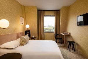 Habitación de hotel con cama y ventana en L'Hôtel, en Nantes