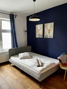 a bedroom with a bed in a blue wall at eM Apartment 17 in Katowice