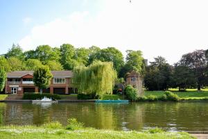 une maison avec un lac en face dans l'établissement Heritage Place by Select SA, à Reading
