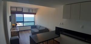 a small living room with a view of the ocean at Marazú OndinaApart in Salvador