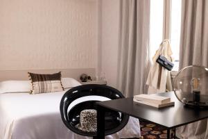 1 dormitorio con 1 cama y 1 mesa con silla en L'Hôtel, en Nantes