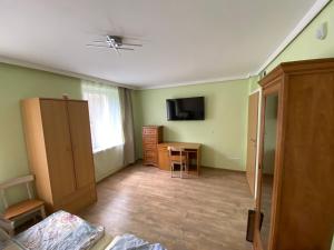 Pokój z zielonymi ścianami, stołem i telewizorem w obiekcie Ratuszowa Noclegi w Szczawnie Zdroju