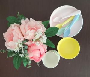 uma mesa com um ramo de flores cor-de-rosa e uma tigela e uma colher em Apartamento familiar em Madri