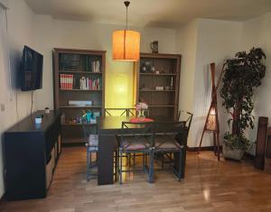 a dining room with a table and chairs and a book shelf at Apartamento familiar in Madrid