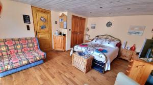 1 dormitorio con 1 cama y 1 sofá en Ty Cosy, Chambre privée en Pluméliau