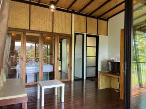 Kunna House في كو ياو نوي: غرفة بها سرير وأبواب زجاجية منزلقة