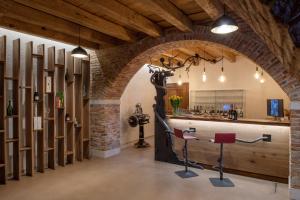 Großes Zimmer mit einer Bar mit zwei roten Stühlen in der Unterkunft AL TIGLIO in Farra di Soligo