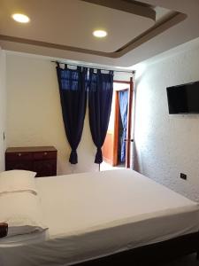 1 dormitorio con 1 cama con cortinas azules y ventana en Apartamento turístico jardín Antioquia, en Jardín