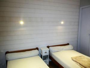 two beds in a room with white walls at Gîtes Merour - Telgruc in Telgruc-sur-Mer