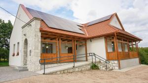 una casa con paneles solares en el techo en Zempléni Tündérkert vendégház, en Füzérkomlós