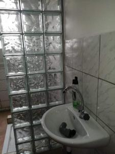 Malomtavi Vendégház Tapolca في تابولتسا: حمام مع حوض وحائط زجاجي