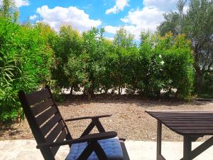 a wooden chair and a picnic table next to a table at Sunny & Bright in Komotini