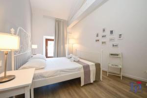 Habitación blanca con cama blanca y escritorio. en Desenzanoloft Peler, en Desenzano del Garda