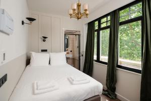 1 dormitorio con cama blanca y ventana en Mr.Lewis Rotterdam, en Róterdam