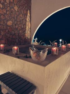 una mesa con velas y luces en una cornisa en Delfini Beach Hotel & Suites, en Archangelos