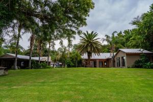 a house with a large lawn in front of it at Riverbank Lodge in Upington