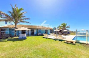 a resort with a pool and some chairs and a building at Pousada Aldeia do Forte in Porto de Sauipe