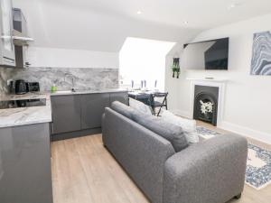 a kitchen and living room with a couch and a table at Sunshine Apartment in Belper