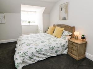 a bedroom with a bed with a pineapple bedspread at Sunshine Apartment in Belper