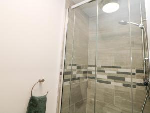 a shower with a glass door in a bathroom at Sunshine Apartment in Belper
