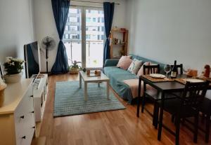 a living room with a blue couch and a table at Apartament MAZI w centrum PRIMORE in Gdańsk