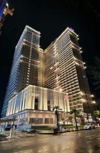 een groot gebouw met twee hoge gebouwen 's nachts bij THE SÓNG Apartment Vũng Tàu - Trinh's House in Vung Tau