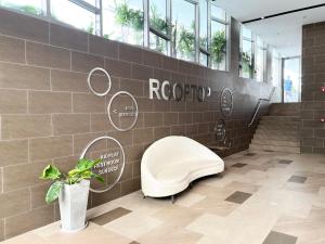 een badkamer met een witte stoel op een tegelmuur bij THE SÓNG Apartment Vũng Tàu - Trinh's House in Vung Tau +279 foto's